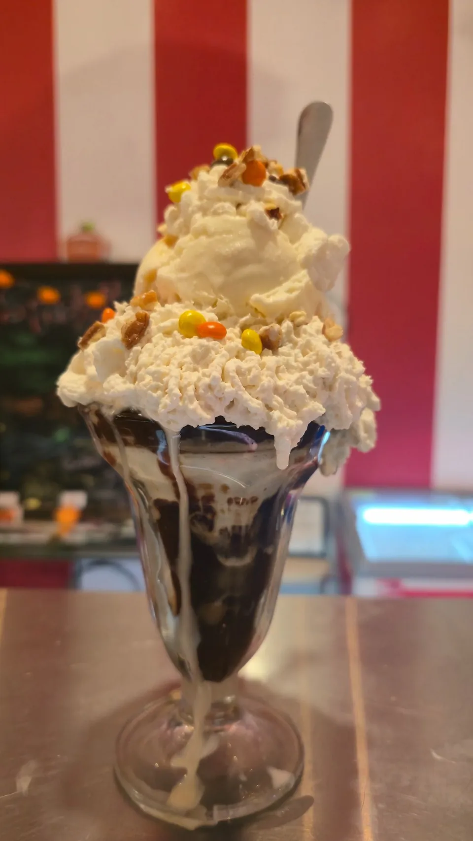 Towering loaded sundae in a classic glass with whipped cream and candy toppings