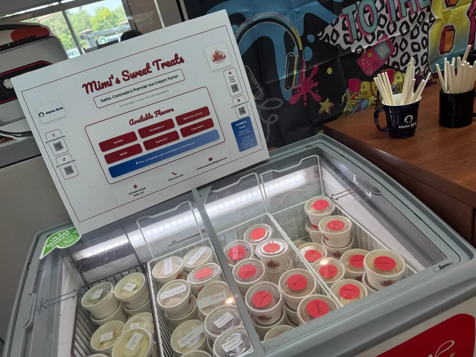 Mimi's Sweet Treats branded freezer display case at a community market event