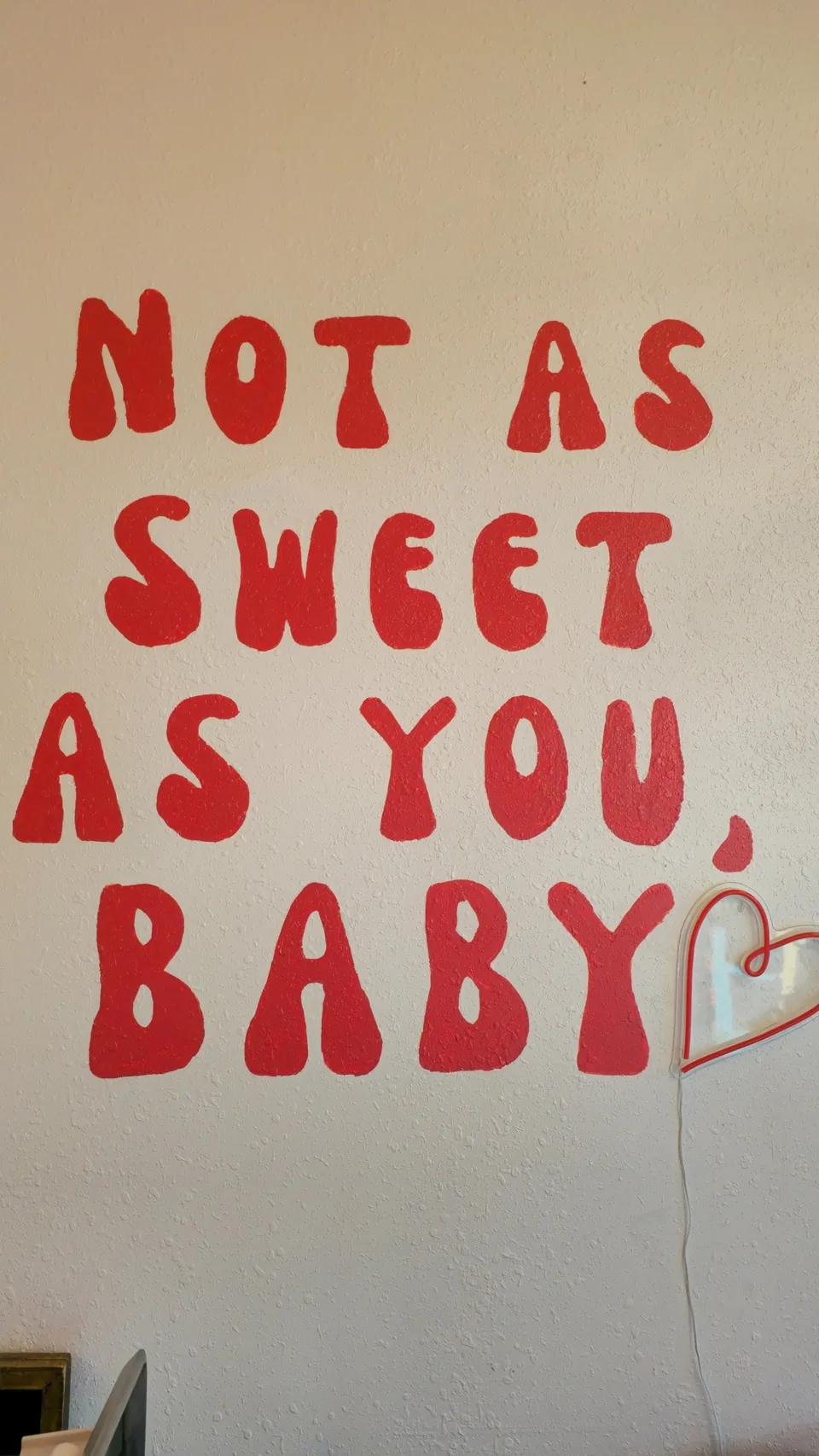 Hand-painted wall mural reading 'Not As Sweet As You, Baby' inside Mimi's Sweet Treats